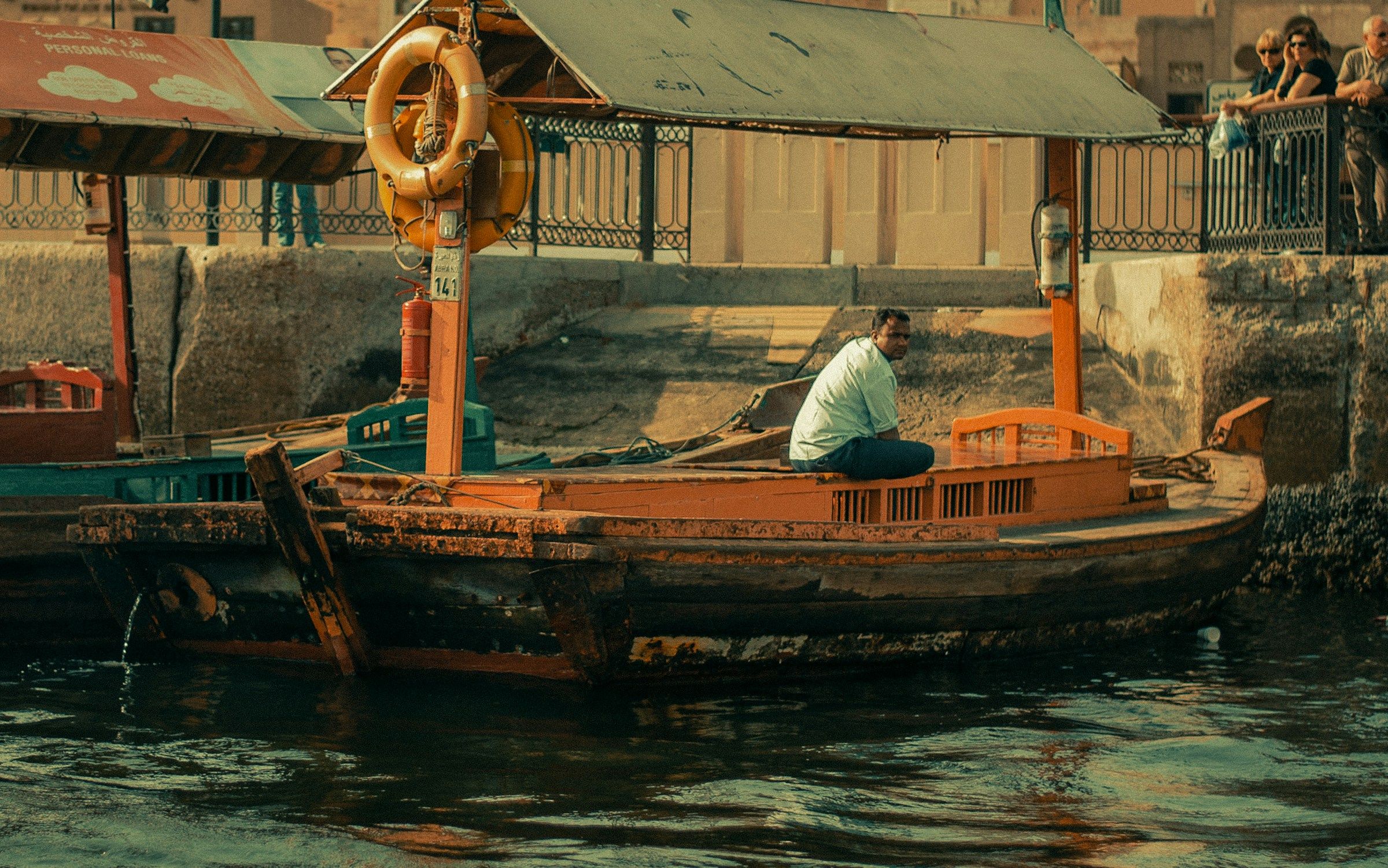 Dubai Creek’te geleneksel ahşap abra teknesinde oturan bir kaptan